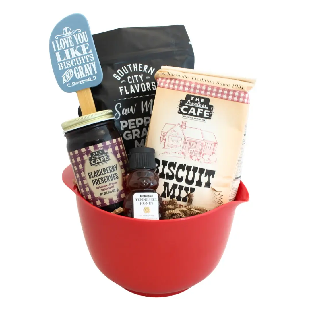 A Taste of the South, Tied with a Bow: High Note Gifts - 4 A red mixing bowl filled with biscuit mix, blackberry preserves, peppered gravy, honey, and a blue spatulaβperfect for Southern gift baskets or anyone craving a true Taste of the South from High Note Gifts.