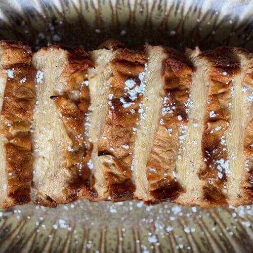 RECIPE: Invisible French Apple Cake - 7 Sliced Invisible French Apple Cake topped with powdered sugar, arranged on a patterned plate.