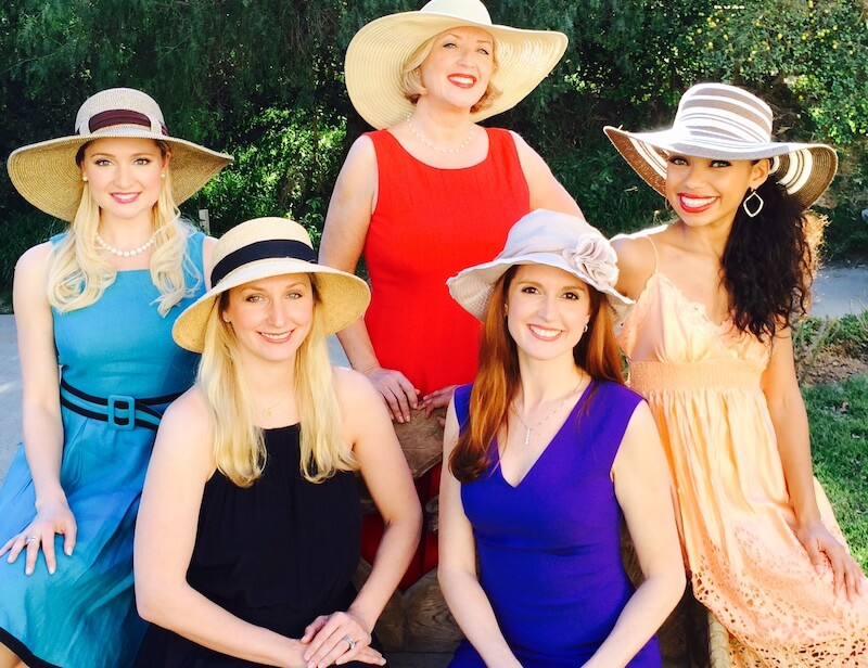 “Too Southern"?! Julia Fowler Would Like a Word - 3 Five women wearing sun hats and colorful dresses pose outdoors, smiling for the camera with greenery in the background—a scene straight out of Julia Fowler's "Too Southern" charm.