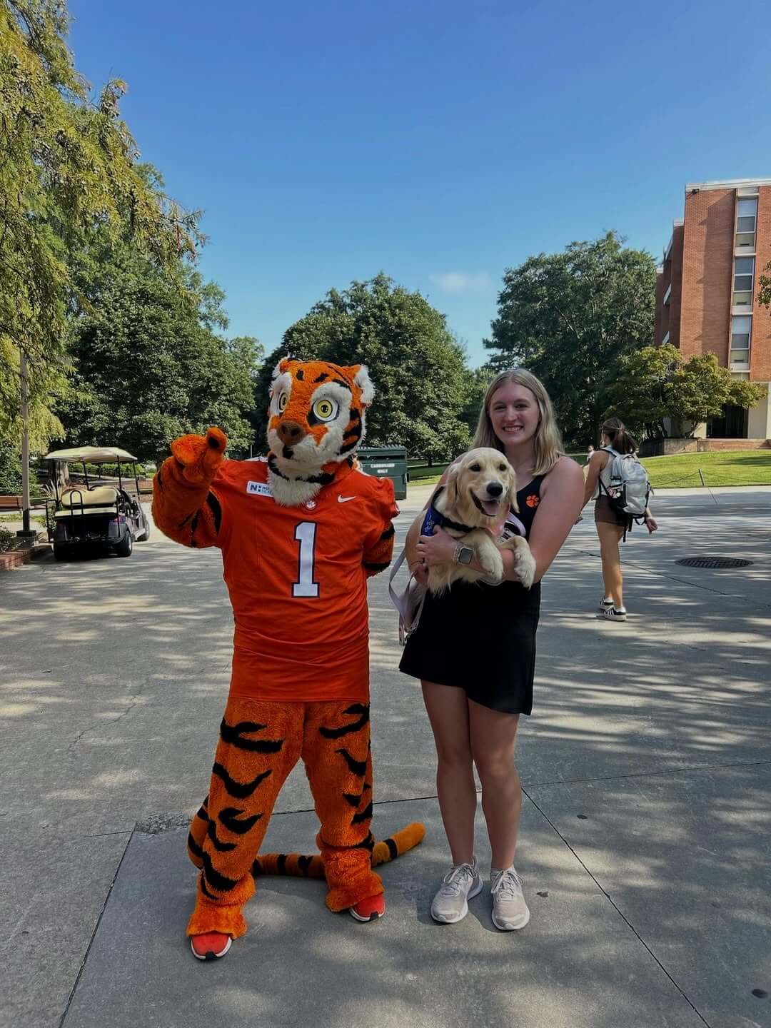 6 Organizations Pairing Canines and Veterans Across the South - 6 The Clemson Tiger mascot stands beside a college student holding a golden retriever that is part of the Battle Buddies training program.