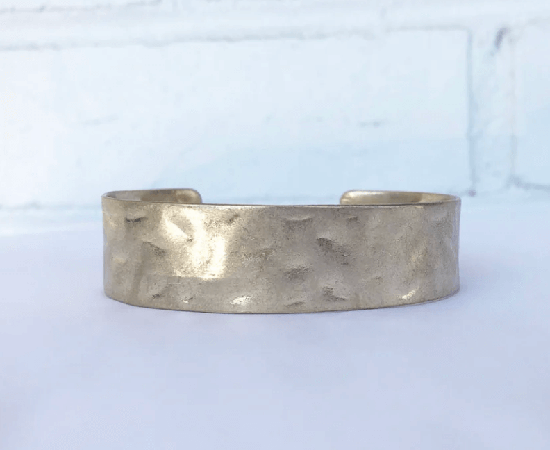 50 Under $50: Your BHAM Holiday Gift Guide - 17 A wide, hammered metal cuff bracelet with a matte finish—an elegant pick for holiday gifts and perfect for any Birmingham Holiday Gift Guide—displayed against a white background.