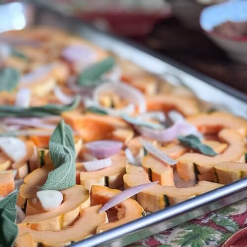 Cooking Unscripted: Roasted Delicata Squash with Apples & Sage - 4 Sliced delicata squash, shallots, and sage leaves arranged on a baking tray, ready for roasting into perfectly roasted delicata squash.