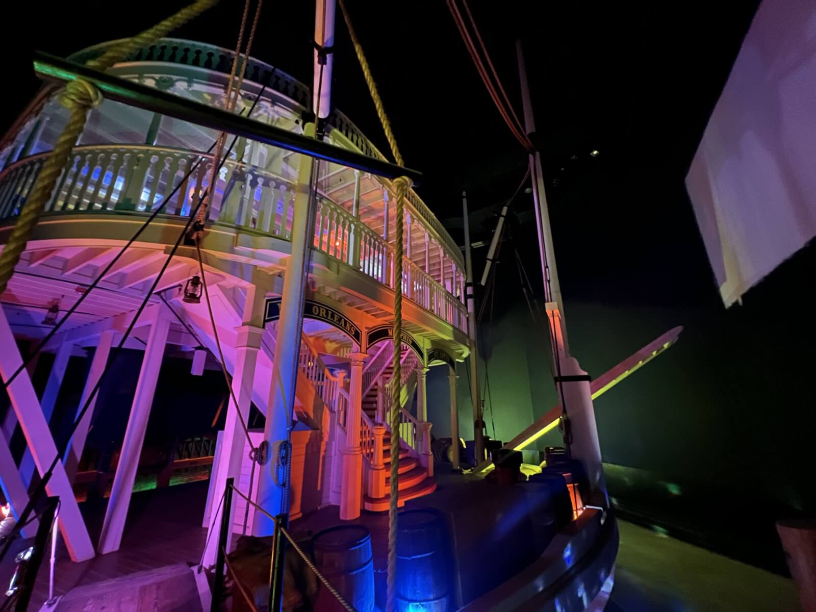 A Sneak Peek at Memphis's Most Buzzed-About New Experience - 6 A brightly lit, multi-level riverboat display featuring colorful lights and barrels, set in a dark indoor environment—perfect for all ages seeking a touch of adventure.