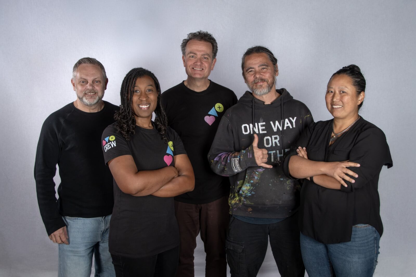 A Sneak Peek at Memphis's Most Buzzed-About New Experience - 3 Five people stand side by side, smiling at the camera against a plain light background. Four wear black tops with badges; one sports a black hoodie with printed text—ready for their next adventure with Baron Von Opperbean.
