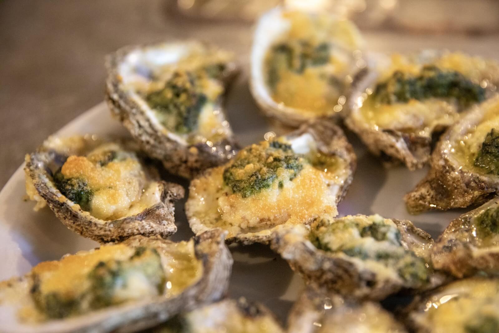 12 Florida Food & Heritage Trails Worth Traveling For - 12 Cajun baked oysters on a white plate.