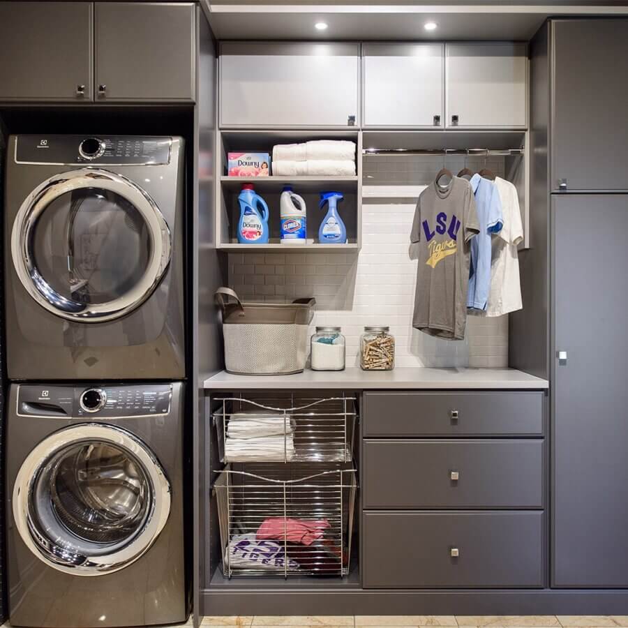 Custom Organization Ideas Homeowners Are Loving Right Now - 8 Modern laundry room with stacked washer and dryer, cleaning supplies, folded towels, hanging shirts, open shelves, drawers, and laundry basket in a sleek cabinet setup—perfect for homeowners seeking smart home organization ideas.