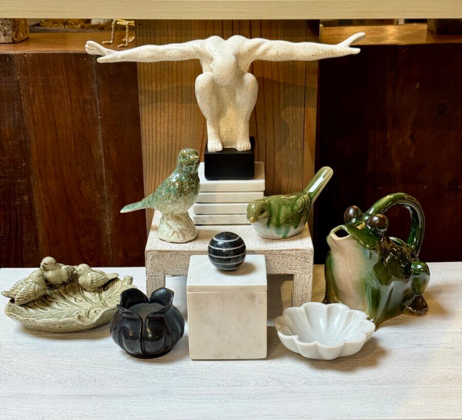 50 Under $50: Your Nashville Holiday Gift Guide - 9 A charming display of ceramic figurinesβbirds, a frog, a human figure with outstretched arms, a black sphere, and small bowlsβmakes unique Gifts Under $50 for your Nashville Holiday Gift Guide, all beautifully arranged on a table.
