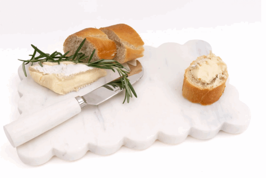 50 Under $50: Your Nashville Holiday Gift Guide - 6 A marble cheese board with sliced baguette, a piece of soft cheese, a sprig of rosemary, and a cheese knifeβperfect for your Nashville gathering or as a chic addition to any Holiday Gift Guide.