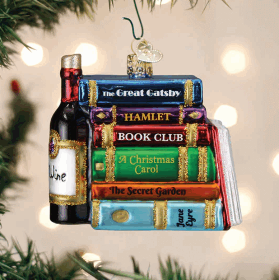 50 Under $50: Your Nashville Holiday Gift Guide - 46 Glass ornament of stacked classic books like "The Great Gatsby" and "Jane Eyre," plus a wine bottle, hanging on a Christmas tree. Featured in our Holiday Gift Guideβan unforgettable Nashville-inspired gift for under $50.