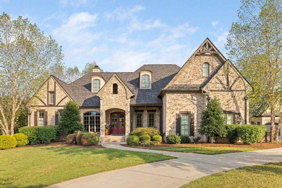 Just Listed! A Franklin Home Where Style & Serenity Coexist - 2 Experience Luxury Living in this stunning two-story stone and brick Franklin Home, featuring a gabled roof, arched entryway, large front windows, manicured lawn, and curved driveway, all nestled amid trees and shrubs for true pastoral peace.