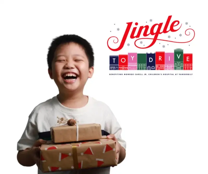 Nashville Toy and Food Drives to Support This Holiday Season - 3 Smiling child holding wrapped presents, next to a "Jingle Toy Drive" logo supporting Monroe Carell Jr. Children's Hospital at Vanderbilt—part of the 2025 Nashville Holiday Drives.