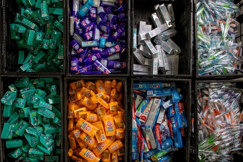 Dignity Starts With a Toothbrush: How The Community Resource Center Quietly Changes Lives in Middle TN - 3 Plastic bins filled with assorted toiletries, including soap, deodorant, sunscreen, toothpaste, and individually wrapped toothbrushes, are available at the Community Resource Center for those in need.