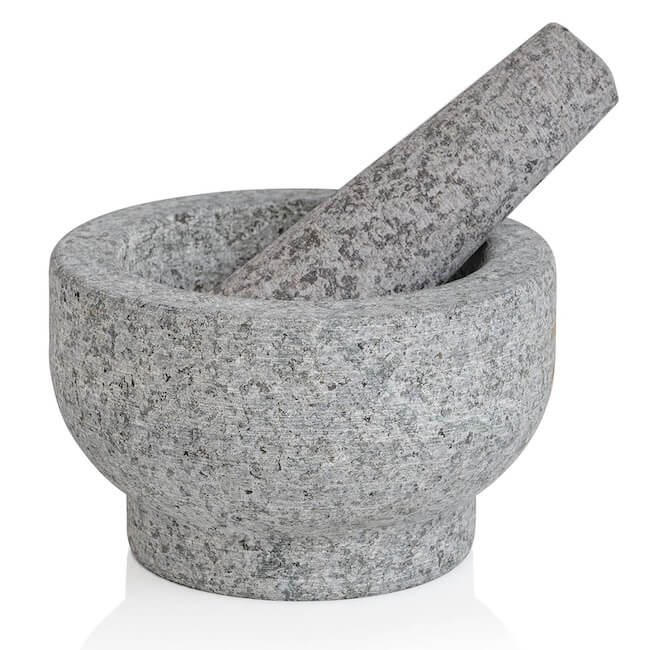 12 Nashville Chefs Share Their Go-To Culinary Gifts to Give - 11 A gray stone mortar and pestle, with the pestle resting inside the mortar, makes a perfect tool for culinary insiders in Nashville, ideal for grinding and crushing ingredients or unique holiday gifts.