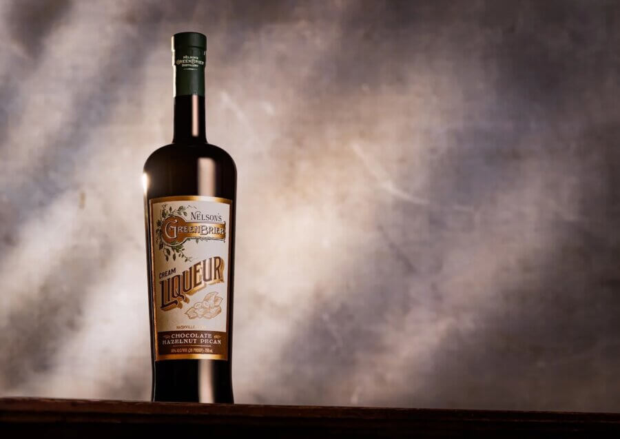 50 Under $50: Your Nashville Holiday Gift Guide - 43 A bottle of Greenbar liqueur stands on a wooden surface against a softly lit, neutral backgroundβan elegant choice for Christmas gifts under $50.