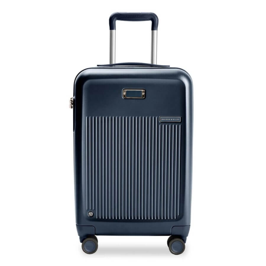 Buy It for Life: 5 Long-Lasting Travel Essentials Loved by Our Readers - 3 A navy blue hard-shell carry-on suitcase with four wheels, an extended telescopic handle, and vertical ridges on the front—perfect for those seeking a buy it for life (bifl) travel companion.