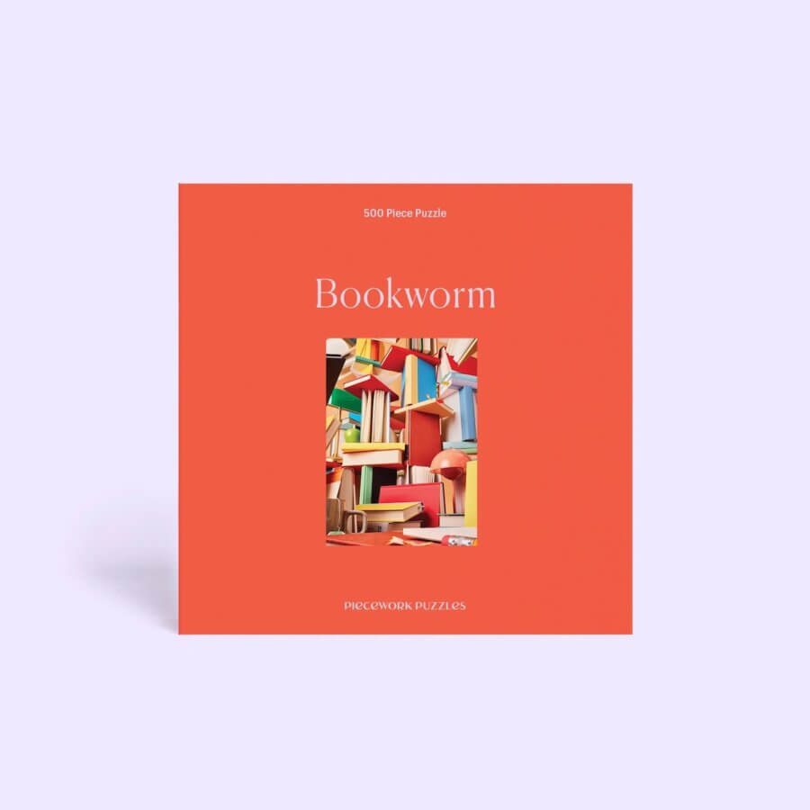 10 Unique Gift Ideas for Book Lovers - 4 A square, orange box labeled "Bookworm" features a vibrant illustration of stacked books and announces a 500 piece jigsaw puzzle by Piecework Puzzles—perfect for book lovers and thoughtful gift ideas.