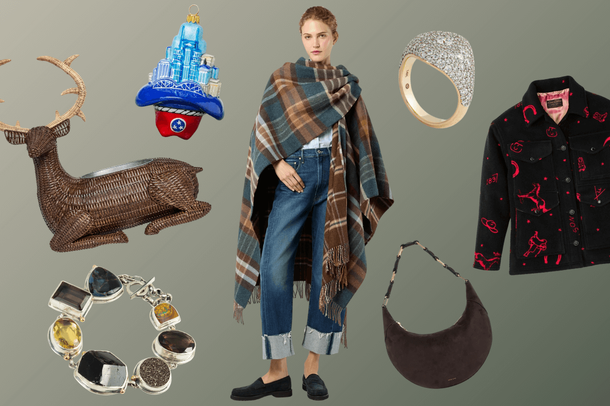 A woman wearing a plaid shawl and jeans is surrounded by accessories, jewelry, a reindeer figurine, a Christmas ornament, a black jacket, and a black shoulder bag—perfect for those seeking expensive gift ideas on a neutral background.