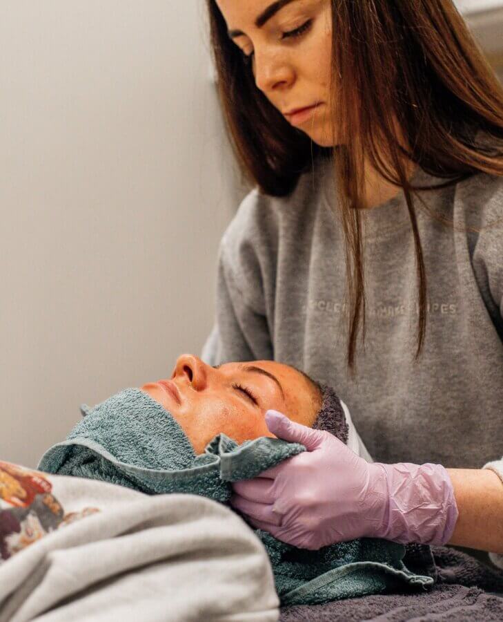 The Best Day Spas in Memphis for a Blissful Escape - 6 A person wearing gloves uses a towel to gently treat another person's face during a pampering skincare or spa procedure, like those offered at the best spas Memphis has to offer.