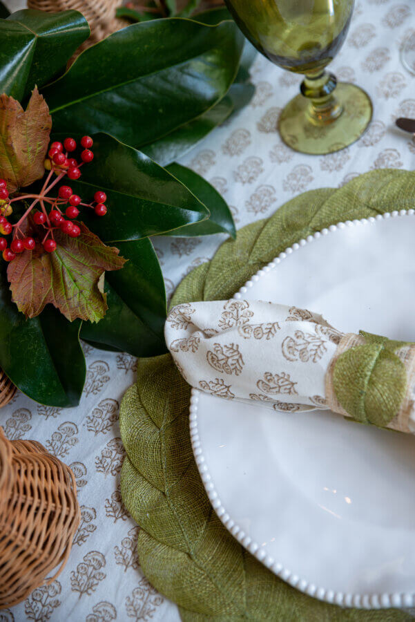 An Event Planner's Guide to Holiday Hosting: Setting the Table, the Mood, and More - 7 Close-up of a white plate with patterned napkin and green accents.