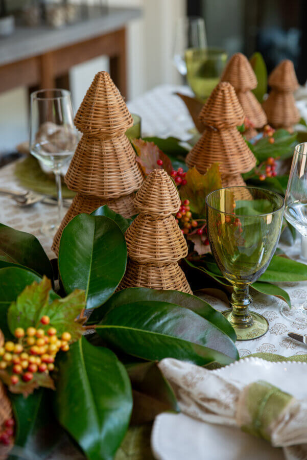 An Event Planner's Guide to Holiday Hosting: Setting the Table, the Mood, and More - 6 Close-up of small woven tree decorations in the middle of a Christmas tablescape