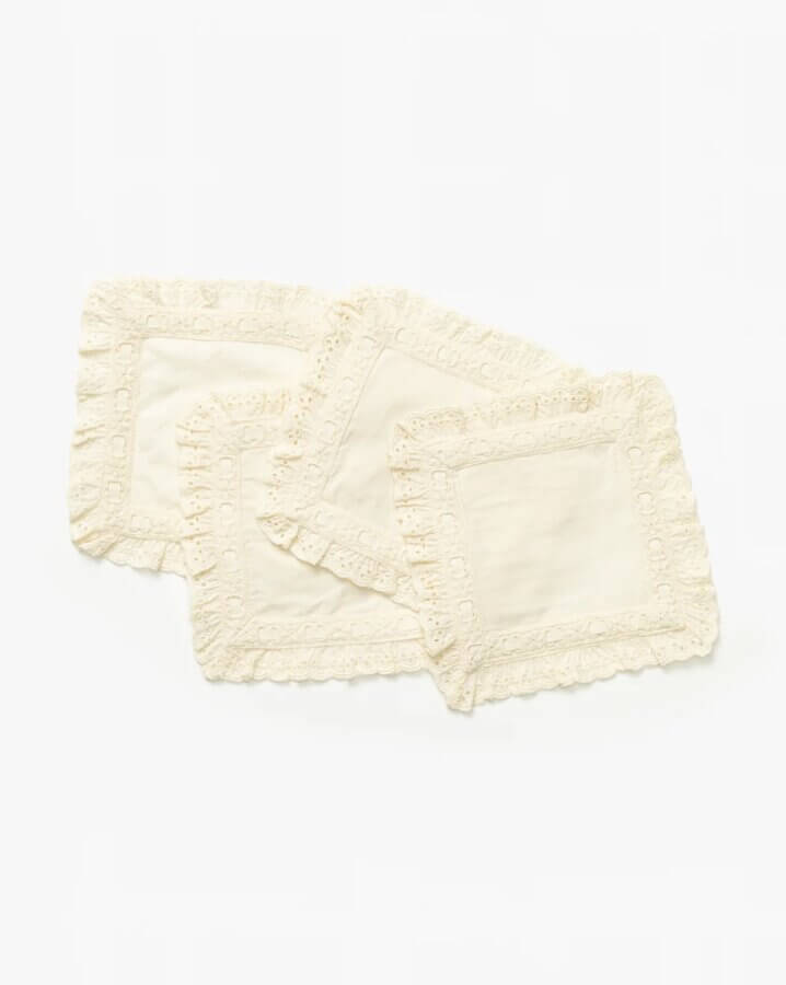 Trend Alert: Lace is Back! - 25 Three cream-colored, rectangular lace-trimmed fabric placemats are stacked in a slightly overlapping arrangement on a white background—a timeless fashion accent for any table.