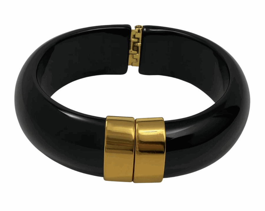 17 Birmingham FINDS for the New Year - 9 A black bangle bracelet with a wide, glossy finish and a gold-toned clasp at the center.
