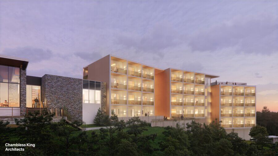 New to BHAM! 5 Exciting Additions Open Now + Coming This Year - 4 A modern multi-story building, BHAM 2026, with illuminated balconies sits on a hillside at dusk, surrounded by trees and partly cloudy skies in the background.