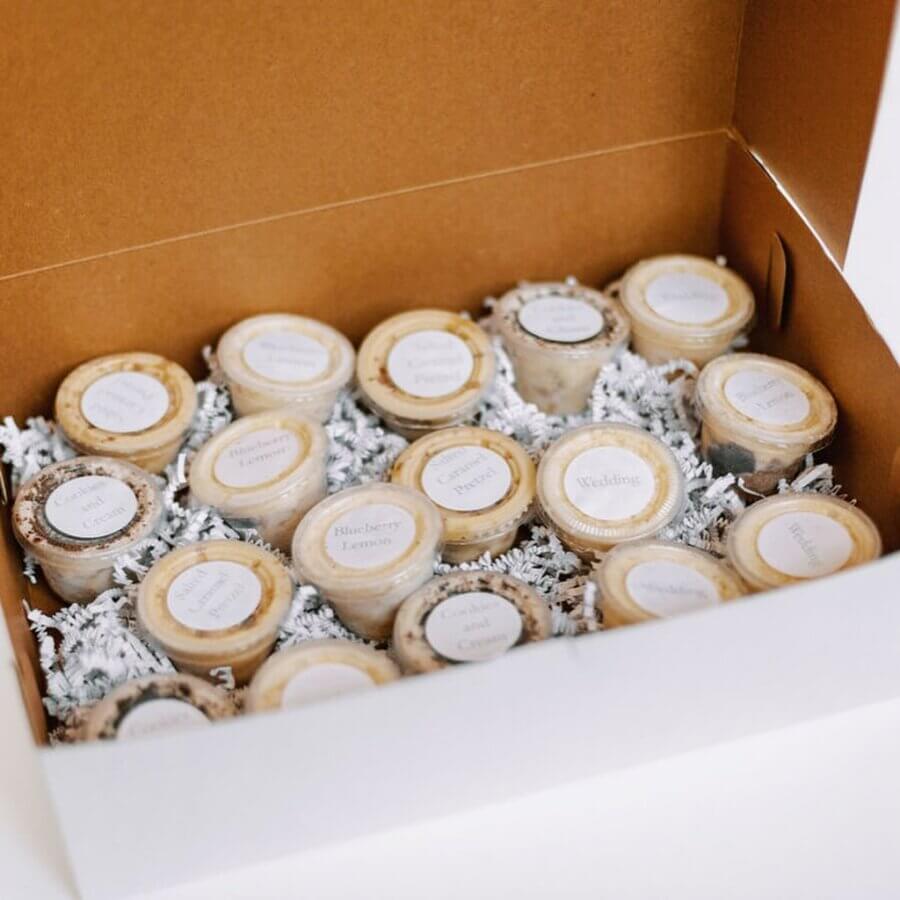 She Bakes Some of BHAM’s Most Iconic Wedding Cakes - 6 An open box containing multiple small containers with labeled lids, arranged in rows and nestled in white crinkle paper.