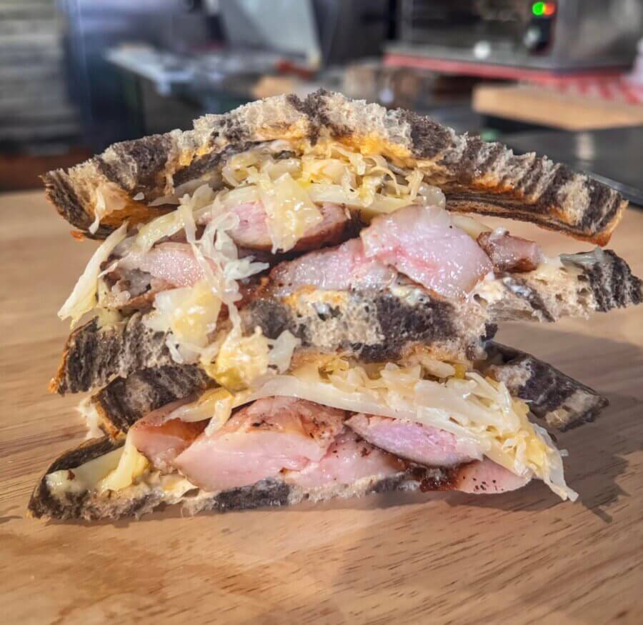 4 New Louisville Restaurants (+2 New Menus!) to Try This Month - 14 A sandwich with meat and cheese on a wood surface.