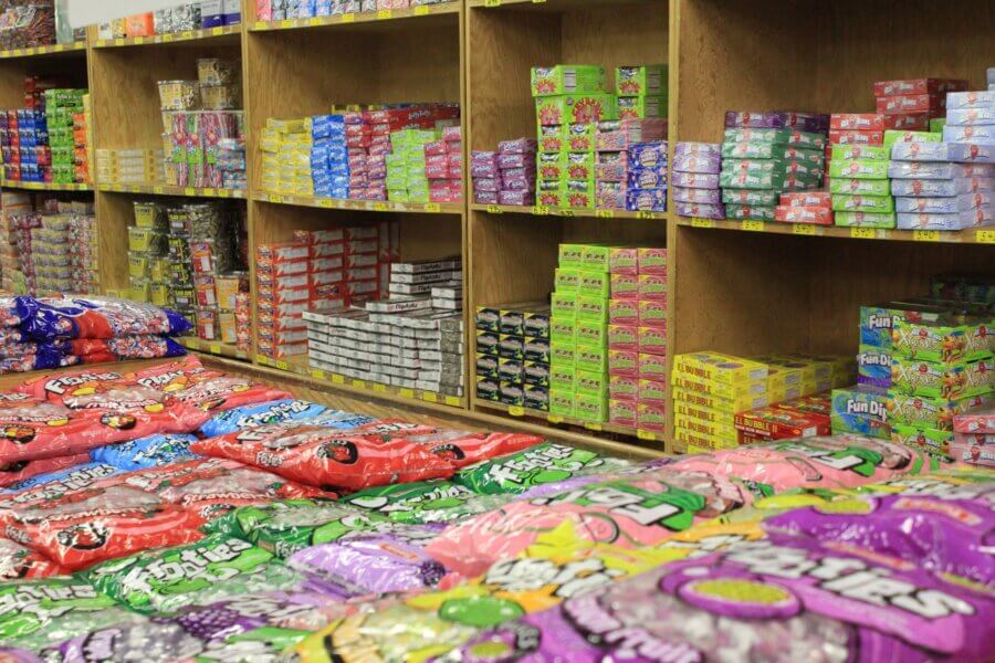 7 Best Candy Shops in Memphis (+ One Local Fave You Can Shop Online) - 8 Shelves and tables filled with assorted colorful packaged candies, including large bags and boxes, await you at one of the best candy shops in Memphis.