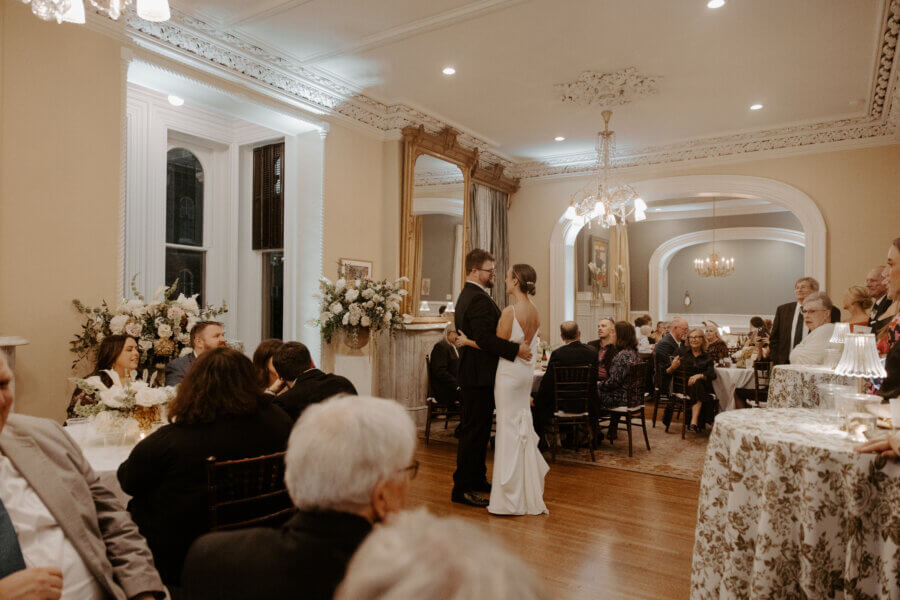 An Elegant Memphis Wedding at The Historic James Lee House - 14 The bride and groom enjoying their first dance as husband and wife at their wedding reception as their guests look on.
