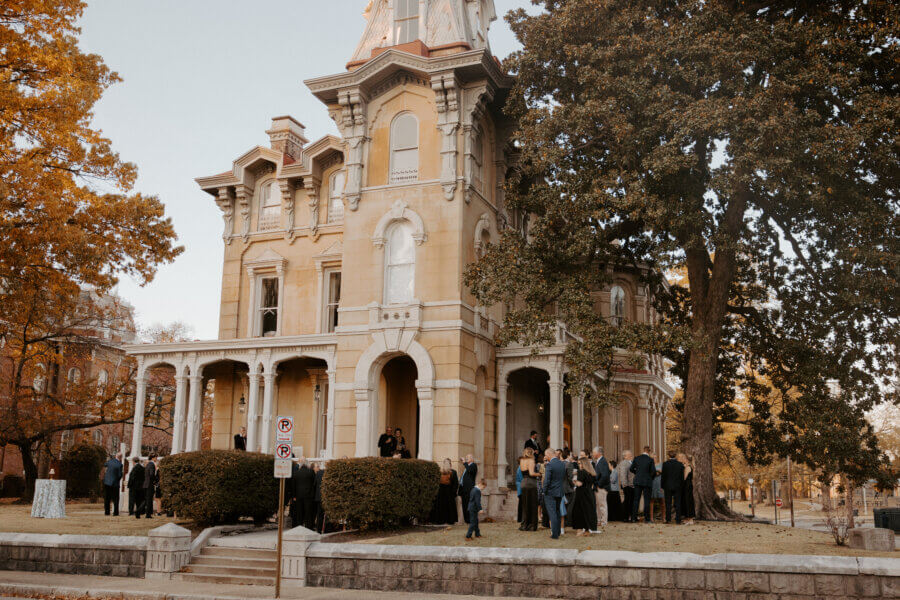 An Elegant Memphis Wedding at The Historic James Lee House - 8 People gathered around the exterior of the Victorian Era James Lee House.