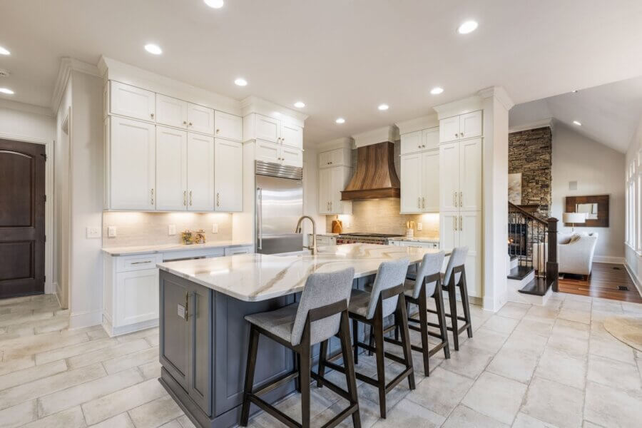 Just Listed! A Franklin Home Designed to Entertain & Unwind - 7 Modern kitchen in this Franklin home features white cabinets, stainless steel appliances, a spacious marble island with four gray barstools—perfect to entertain or unwind. Open layout seamlessly connects to the inviting living area.