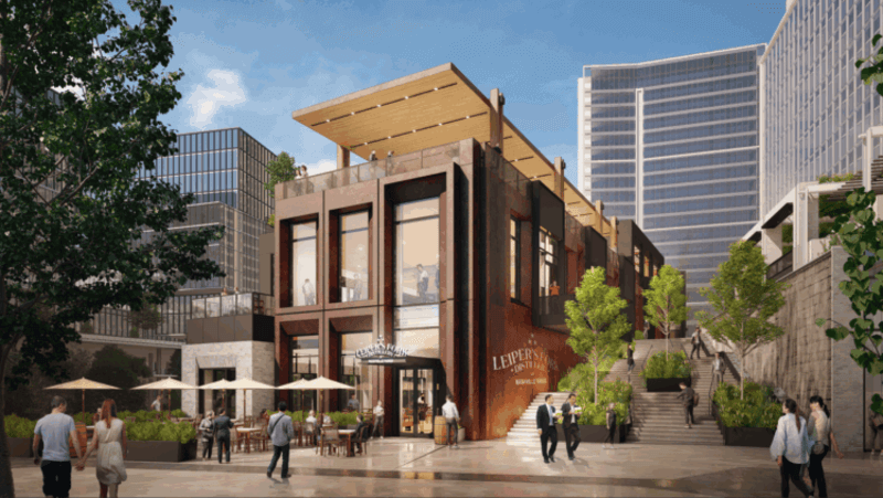 Coming Soon to Nashville! 10 Exciting Additions - 5 Modern urban building with large windows and rooftop seating, surrounded by trees, outdoor tables, and people walking in a lively Nashville plaza—an inviting scene imagined for 2026.
