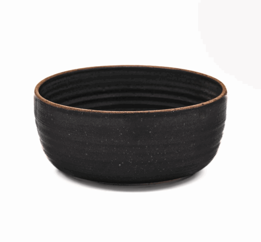 16 Nashville FINDS for a Winter Refresh - 14 A round, black, ceramic bowl with a textured, matte finish and slightly tapered sides evokes a sense of Winter Reset, set against a plain white background—perfect for cozy Nashville gatherings.