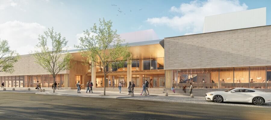 Coming in 2026! Exciting Developments to Watch Around the South - 6 Modern building with large windows and wooden accents, people walking on the sidewalk, trees lining the street, and a white car parked in front—an example of the exciting developments coming to South developments in 2026.