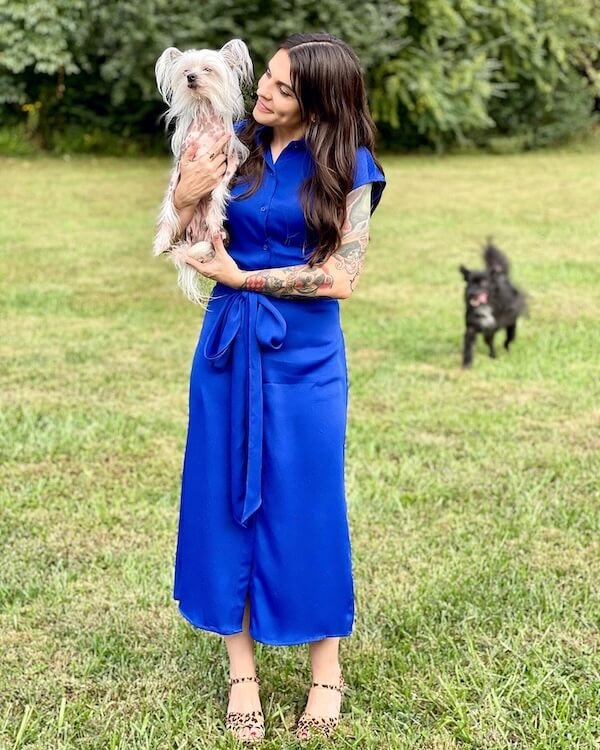 She Connects Pets & People at Nashville Humane Association - 3 A woman in a bright blue dress stands in the grass with her dog.