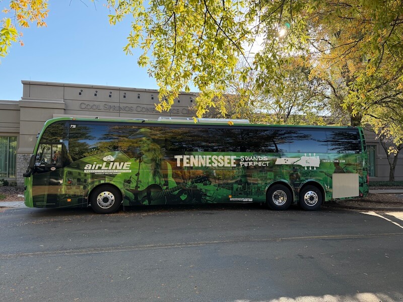 6 New Nashville Services to Elevate Your Everyday - 2 A green tour bus with "Tennessee Sounds Perfect," "airLINE" branding, and a nod to new Nashville services is parked in front of the Cool Springs Conference Center on a sunny day.