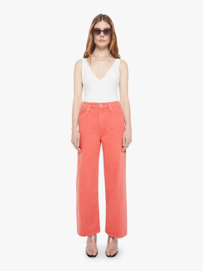 6 Spring 2026 Fashion Trends + How to Wear Them - 10 A woman showcases how to wear red wide-leg jeans, a white sleeveless top, sunglasses, and clear-heeled sandals—capturing the essence of Spring 2026 fashion trends against a plain white background.