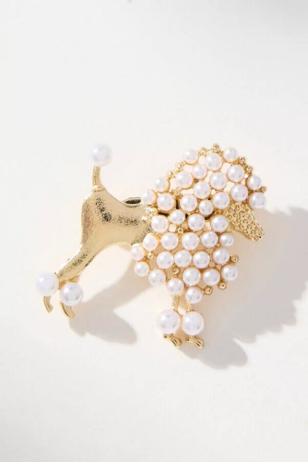 6 Spring 2026 Fashion Trends + How to Wear Them - 6 Gold poodle-shaped brooch decorated with clusters of small white pearls on the body, tail, and feet, set against a light background—a charming accessory to elevate your Spring 2026 style.