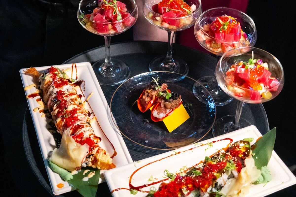 A tray with shrimp tempura rolls, sushi topped with red roe, and martini glasses filled with diced tuna and garnishes—perfect for sampling the flavors at new restaurants in Birmingham.