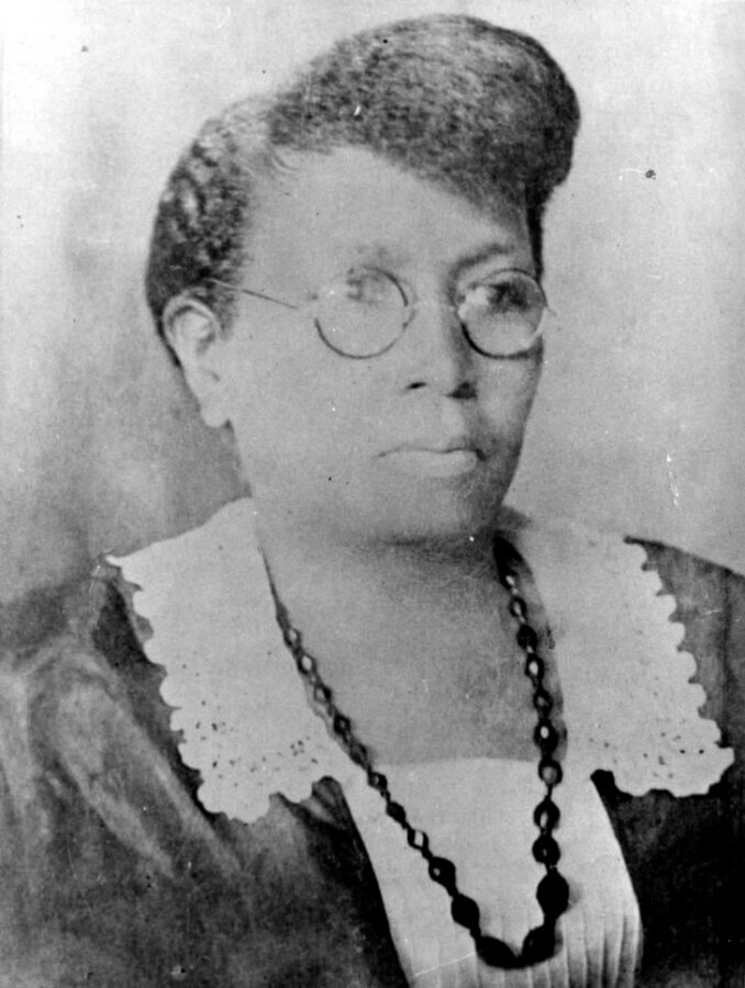 4 Remarkable Women in Birmingham's Black History - 2 Black-and-white portrait of Carrie A. Tuggle wearing glasses, a lace-collared dress, and a long beaded necklace, with her hair styled up.