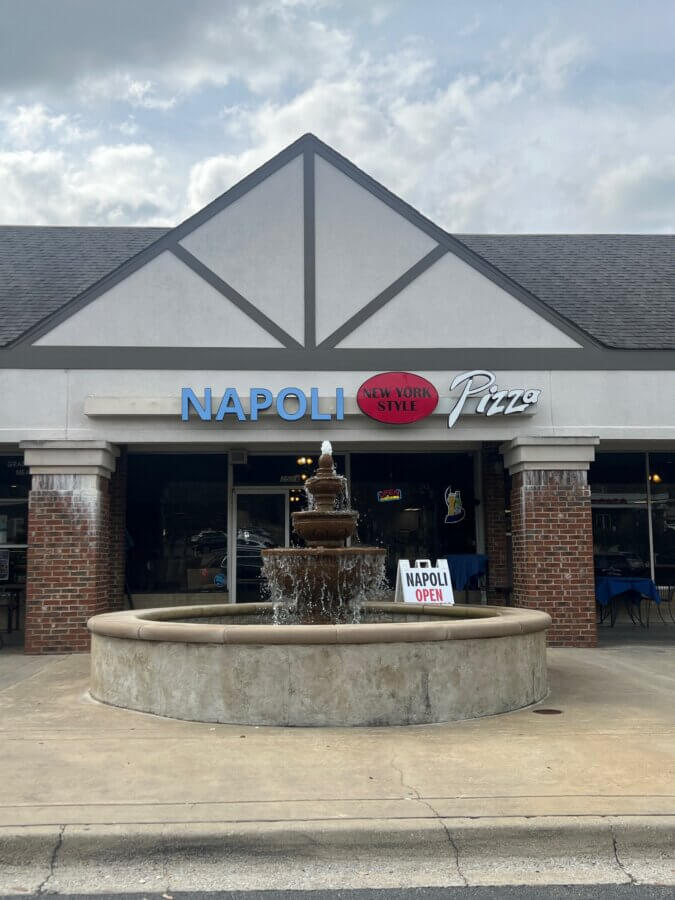 10 New Birmingham Restaurants to Try This Month - 17 A brick-front pizza restaurant with a fountain in front, featuring signs that read "NAPOLI Pizza," "New York Style," and "NAPOLI OPEN.