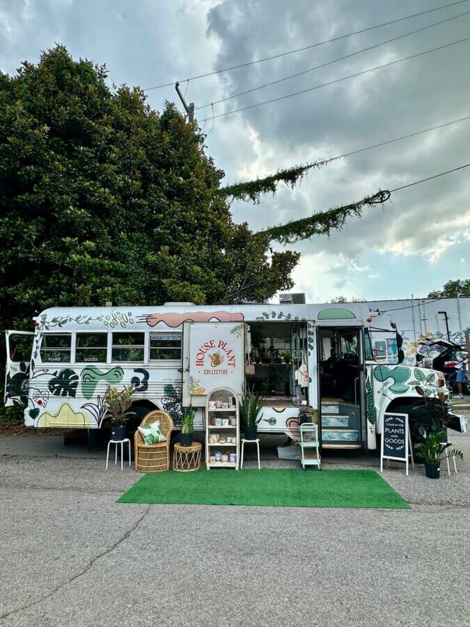 Meet Jessica Watts of BHAM's House Plant Collective - 5 A decorated bus, run by Jessica Watts, serves as a mobile plant shop with shelves of house plants and a sign reading "House Plant Collective" displayed outside.