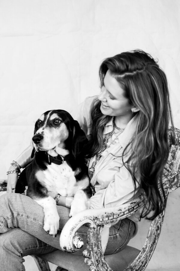 Heirloom Jewelry, Reimagined: Meet Designer Brooke Griffith - 7 A Nashville artist sits on an ornate chair holding a dog in her lap. Both are facing slightly left.