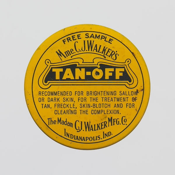 Madam C.J. Walker: The South's First Female Beauty Mogul - 4 Round yellow tin labeled "Mme. C.J. Walker's TAN-OFF," a skin product sample from Indianapolis by Madam C.J. Walker, recommended for clearing and brightening complexion.