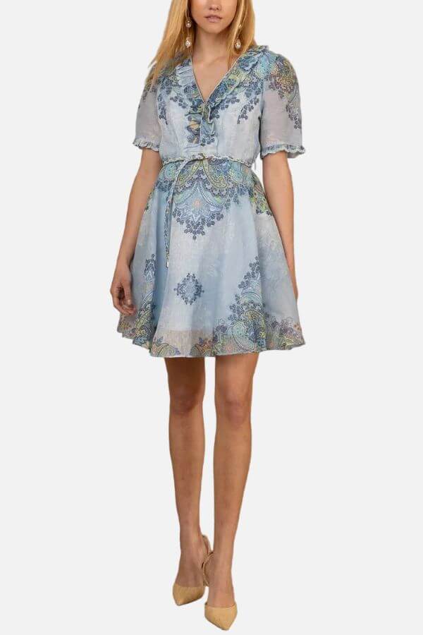 15 Memphis FINDS to Welcome Spring - 3 Woman wearing a light blue, short-sleeve, knee-length dress with a floral pattern, V-neckline, tie belt, and beige heels—one of our favorite Memphis finds for February.