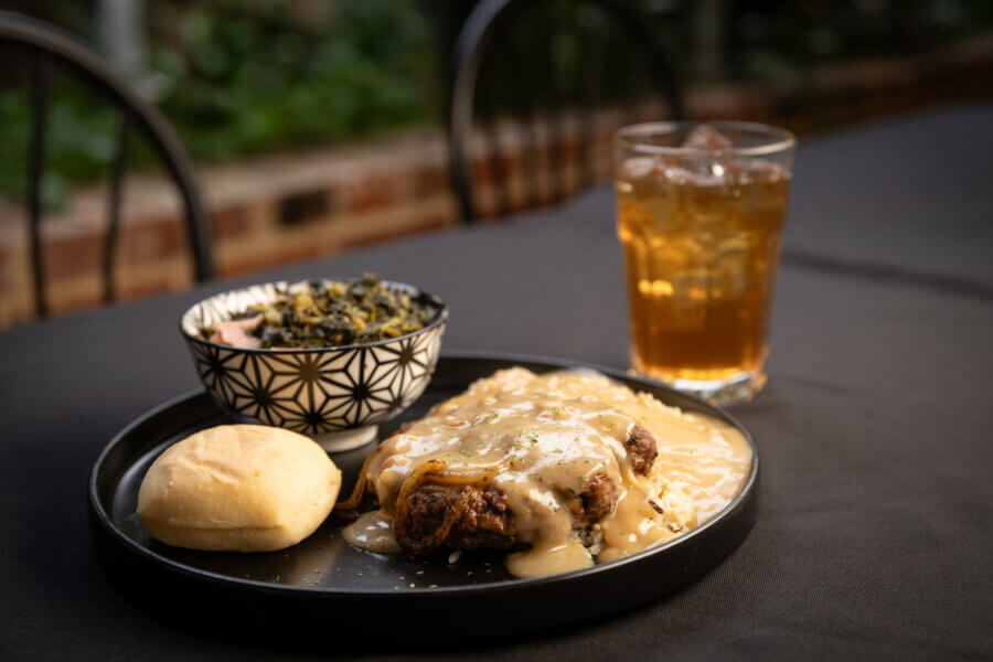 A plate of soul food, including a bowl of greens and sweet tea, at a Mississippi restaurant.