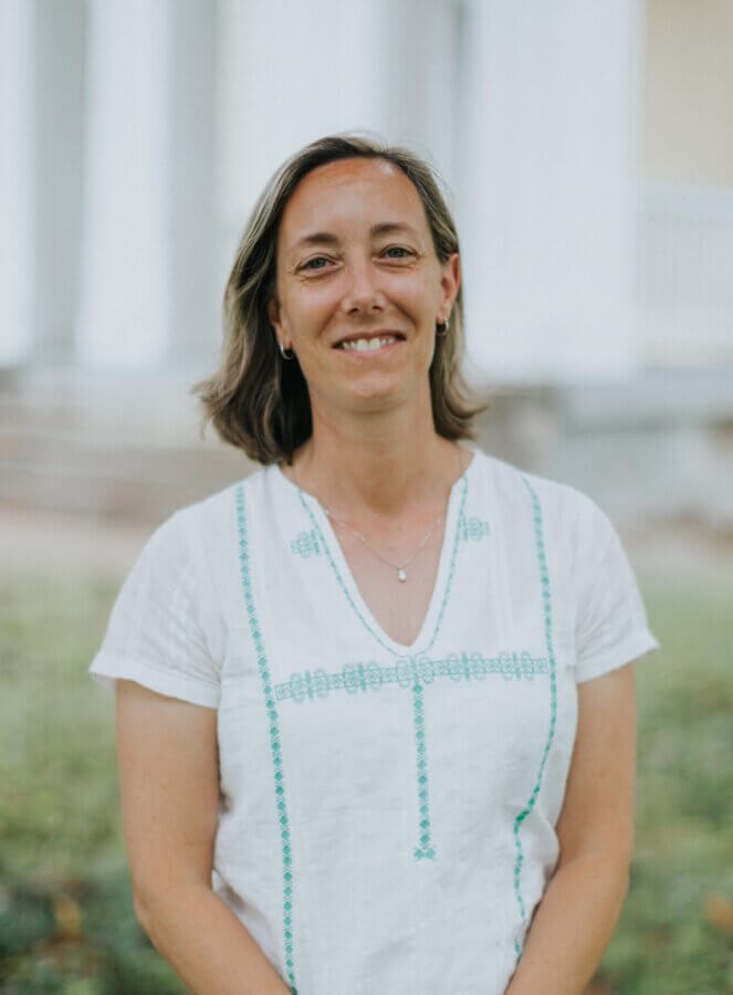 She’s Putting Nashville’s Hidden History on the Map - 3 Dr. Mary Ellen Pethel, a woman with shoulder-length brown hair wearing a white short-sleeve shirt, stands outside in front of white columns, smiling at the camera.
