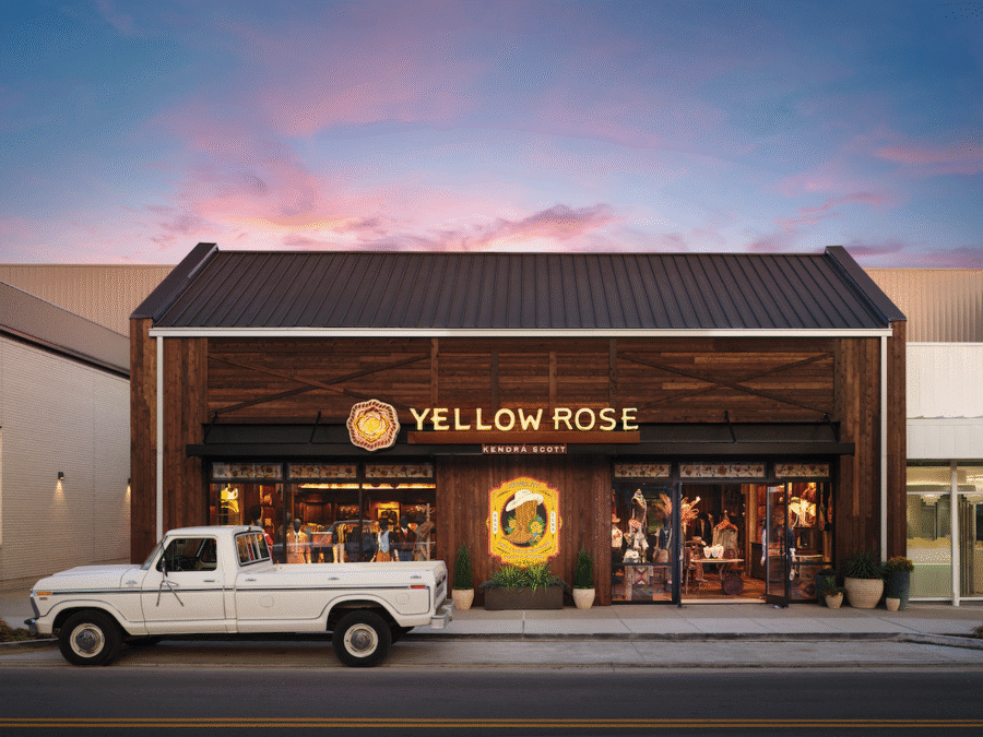 9 New Nashville Retail Spots to Explore - 10 A white vintage pickup truck is parked in front of the Yellow Rose Kerbey & Short restaurant at sunset, with warm lights glowing inside the wooden exterior building near some charming Nashville stores.